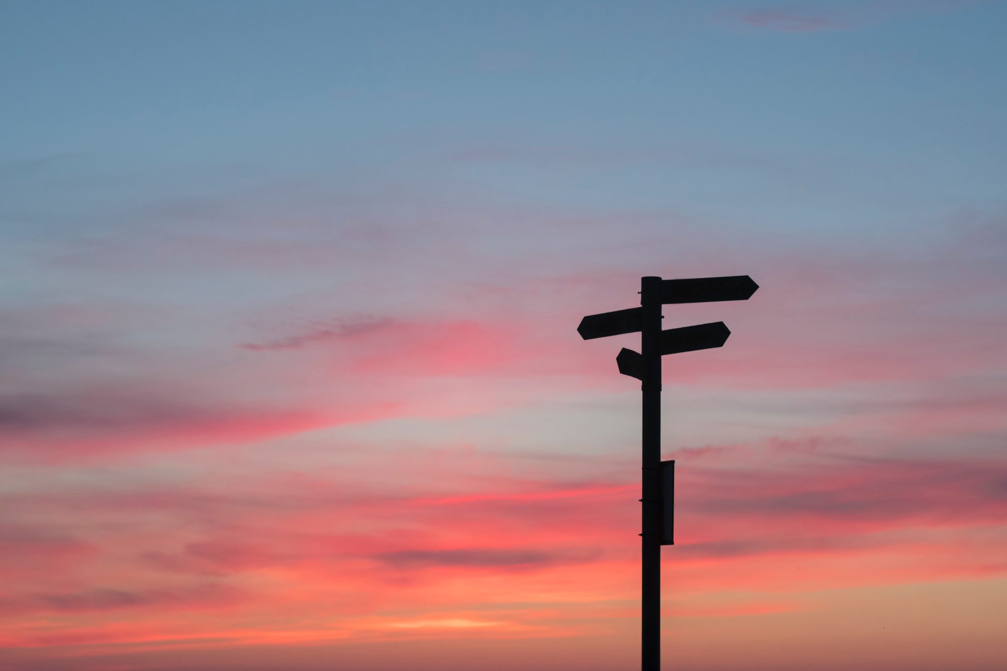 Wegweiser schemenhaft vor Sonnenuntergang - Symbolbild Use Case