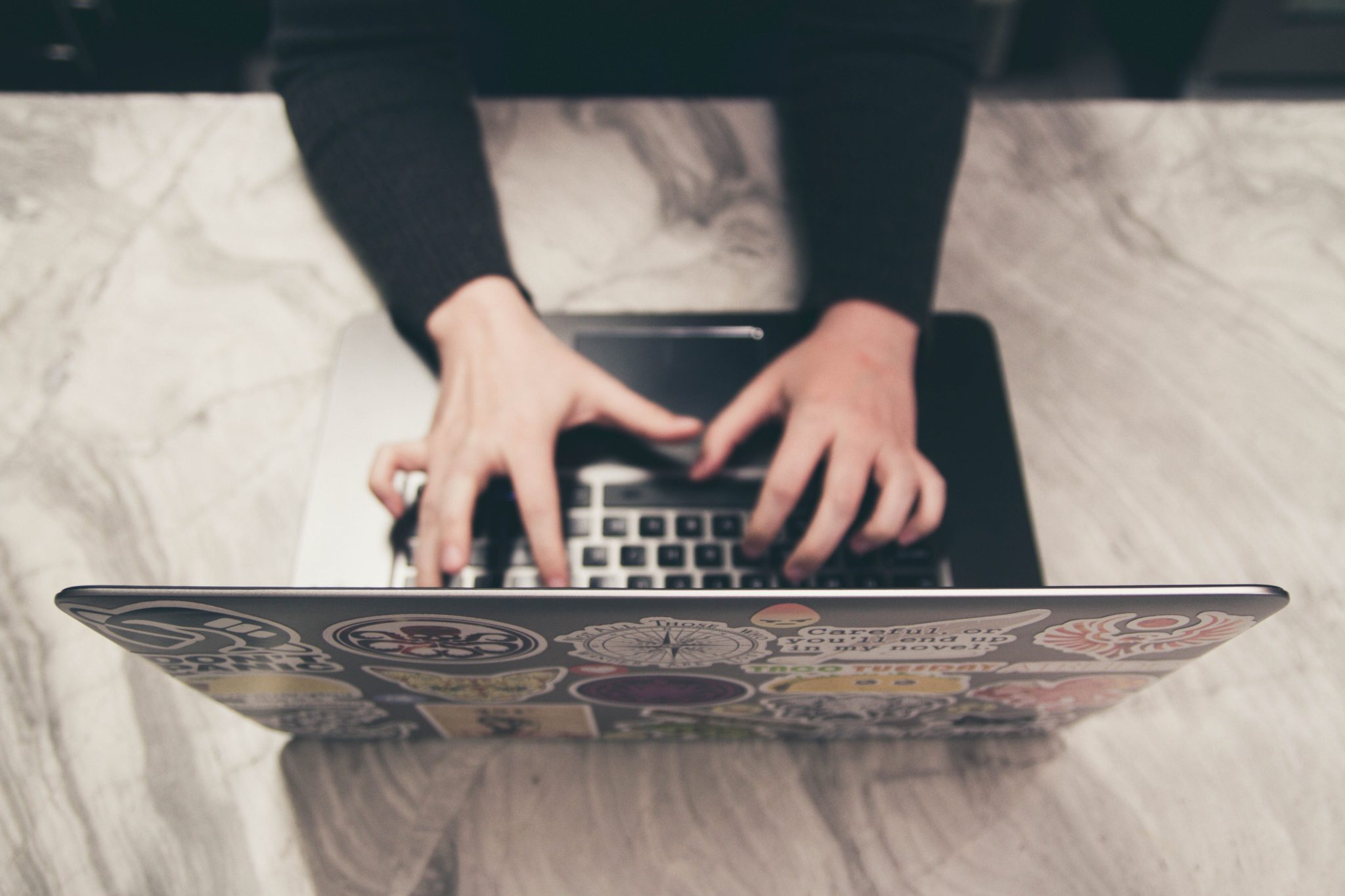 Laptop von oben mit tippenden Frauenhänden - Symbolbild für Spenden mit Mailing sammeln